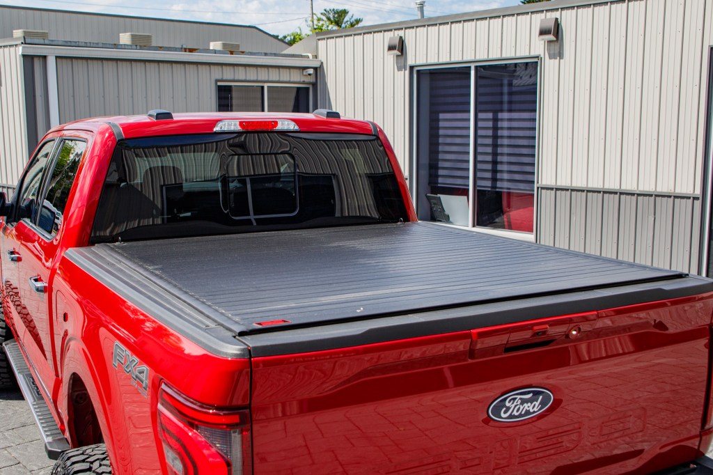 A 2025 Ford F-150 with a hard roll-up bed cover, a 6" Rough Country lift kit, 22x12 Fuel Rebar wheels, and 35" Fury Country Hunter R/T tires.
